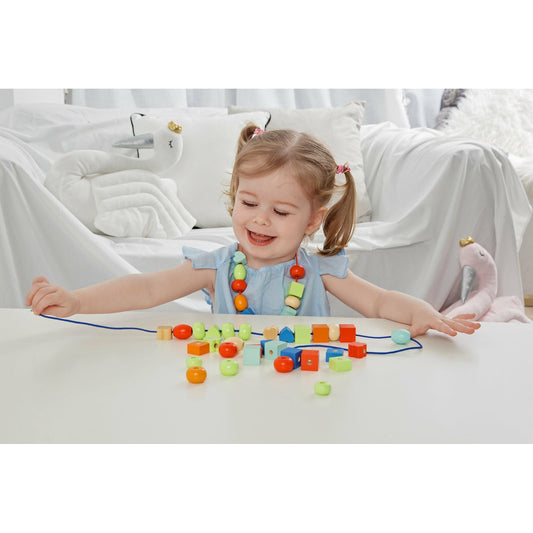 Girl stringing colourful beads to make a beautiful necklace or a bracelet